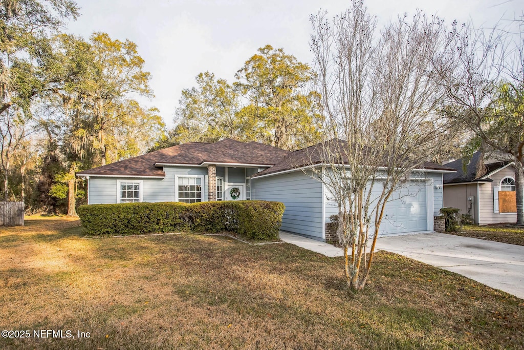 ranch-style home with a garage and a front lawn