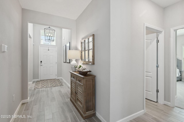 foyer entrance featuring a chandelier and light hardwood / wood-style floors