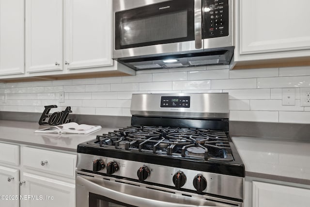 kitchen with appliances with stainless steel finishes, tasteful backsplash, and white cabinetry