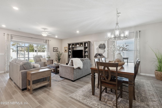 dining room featuring ceiling fan with notable chandelier