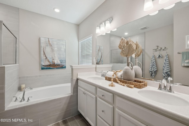 bathroom featuring vanity and tiled bath