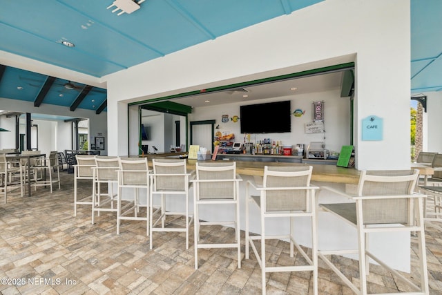 view of patio featuring ceiling fan and exterior bar