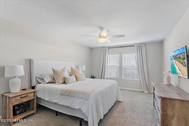 bedroom with light carpet, baseboards, a textured ceiling, and ceiling fan