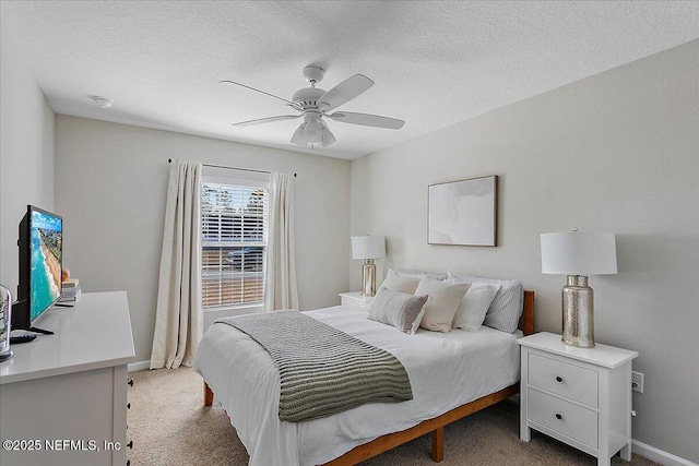 carpeted bedroom featuring baseboards, a textured ceiling, and ceiling fan