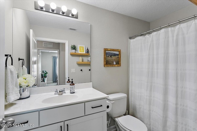 bathroom with visible vents, toilet, a textured ceiling, and vanity