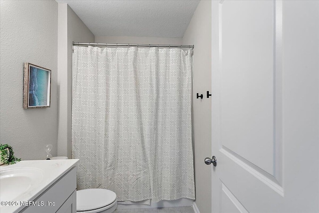 bathroom featuring vanity, a shower with shower curtain, a textured ceiling, toilet, and a textured wall