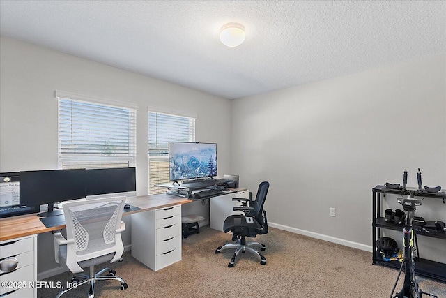 office space with light colored carpet, baseboards, and a textured ceiling