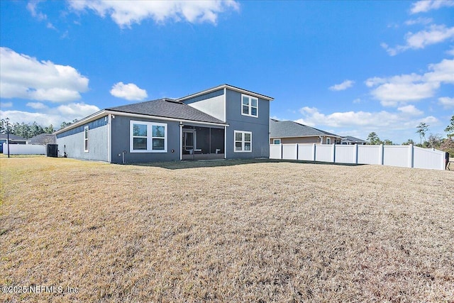 rear view of property with central air condition unit, a lawn, fence, and a sunroom