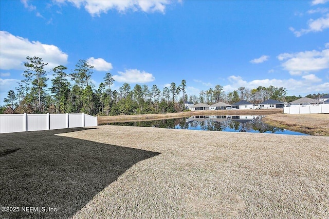 view of yard featuring fence and a water view