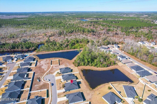 aerial view featuring a wooded view, a water view, and a residential view