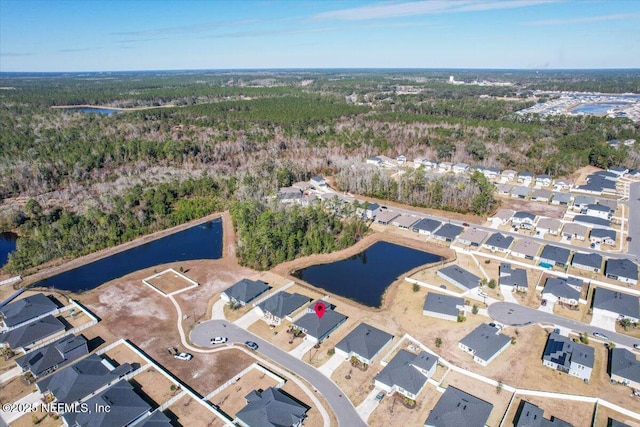 birds eye view of property with a forest view, a residential view, and a water view