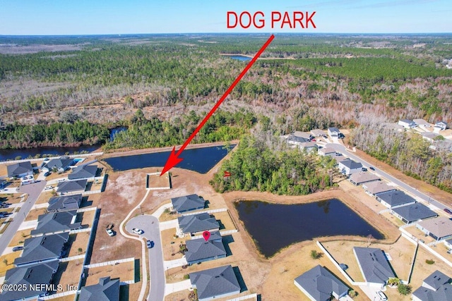 aerial view featuring a residential view, a wooded view, and a water view