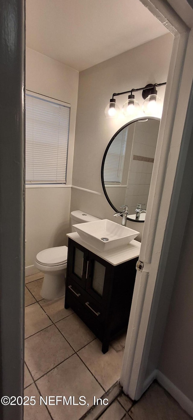 bathroom with toilet, tile patterned flooring, and vanity