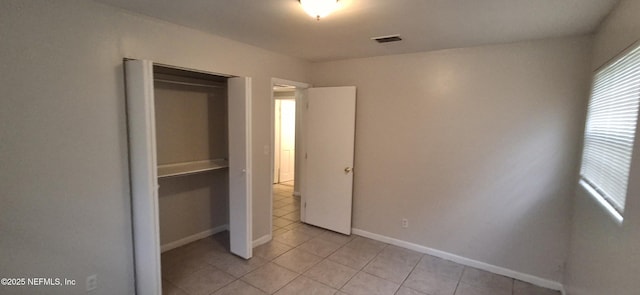 unfurnished bedroom featuring a closet and light tile patterned flooring