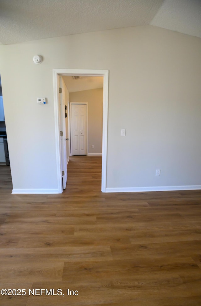 unfurnished room with lofted ceiling and hardwood / wood-style flooring