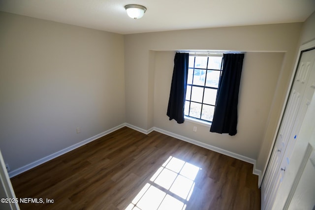 empty room with dark hardwood / wood-style flooring