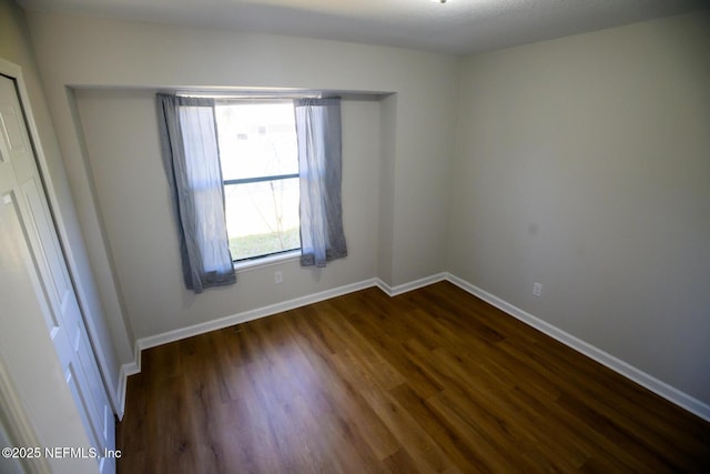 unfurnished room featuring a healthy amount of sunlight and dark hardwood / wood-style flooring