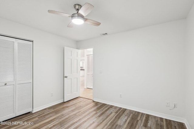 unfurnished bedroom featuring a closet, ceiling fan, and light hardwood / wood-style flooring