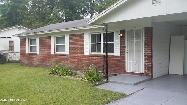 view of exterior entry featuring a lawn