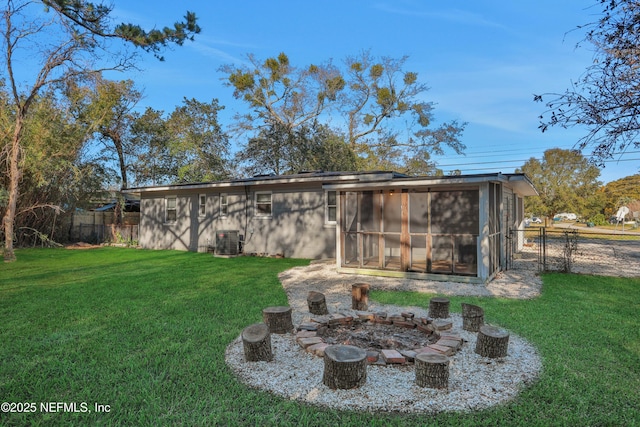 view of yard with an outdoor fire pit, a sunroom, and central air condition unit