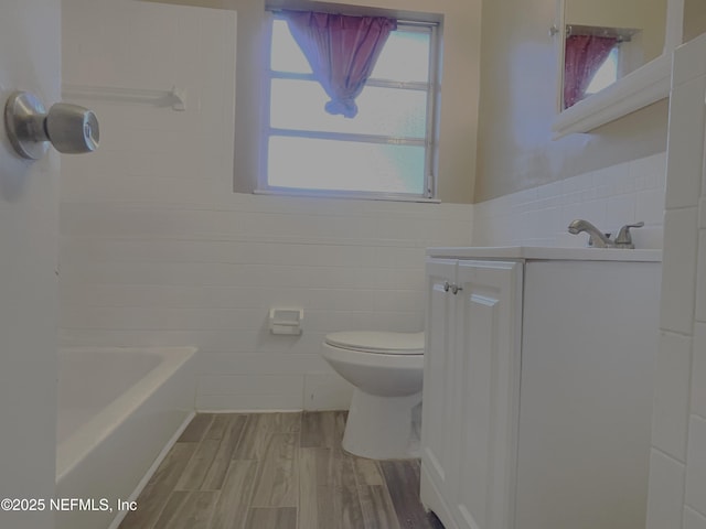 bathroom with hardwood / wood-style flooring, vanity, tile walls, and toilet