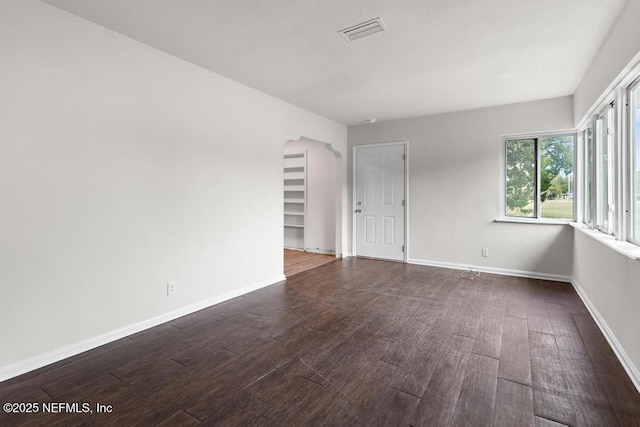 empty room with dark hardwood / wood-style flooring