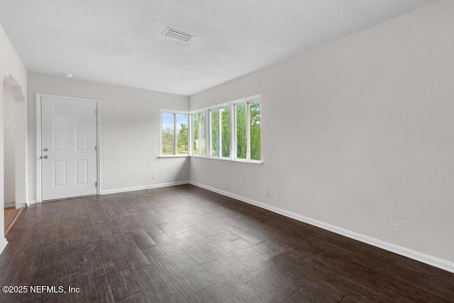 unfurnished room featuring dark wood-type flooring