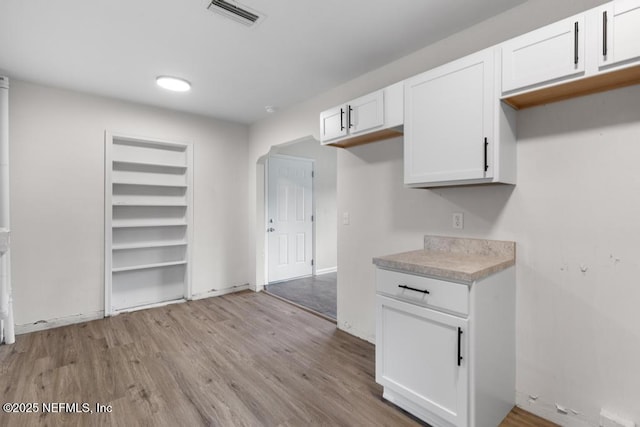 kitchen with white cabinets and light hardwood / wood-style floors