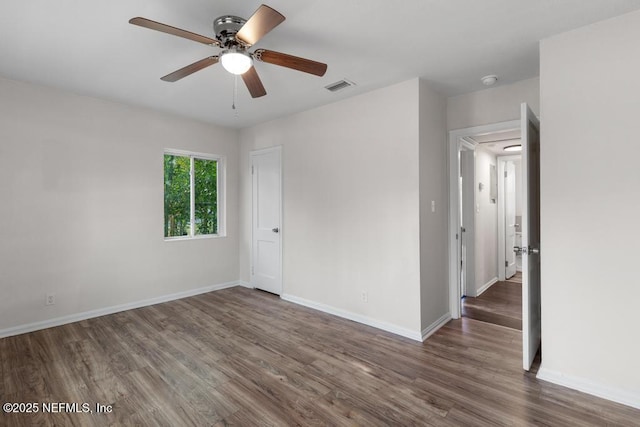 unfurnished room featuring ceiling fan and dark hardwood / wood-style flooring