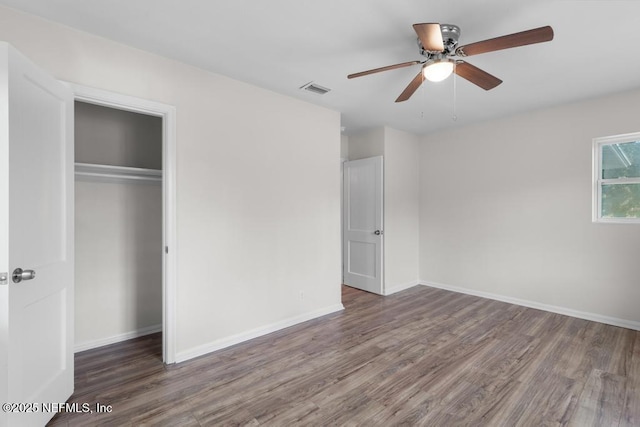 unfurnished bedroom featuring a closet, ceiling fan, and dark hardwood / wood-style flooring