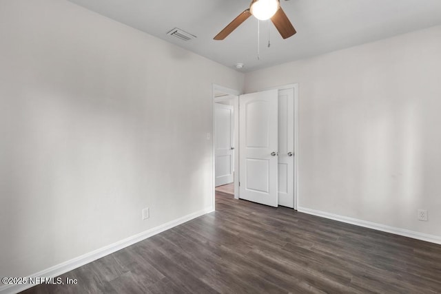 empty room featuring ceiling fan and dark wood-type flooring