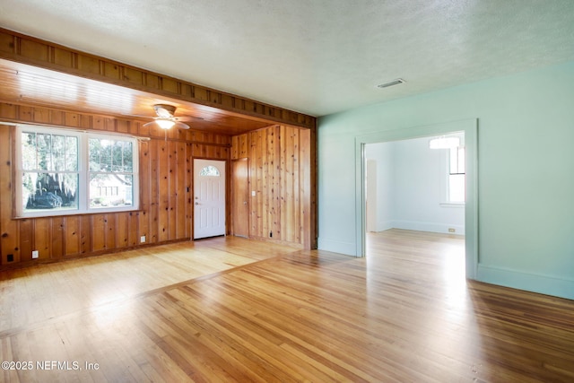 spare room with ceiling fan, light wood-type flooring, and a textured ceiling