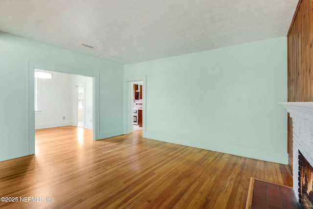 unfurnished living room with a fireplace and light hardwood / wood-style flooring