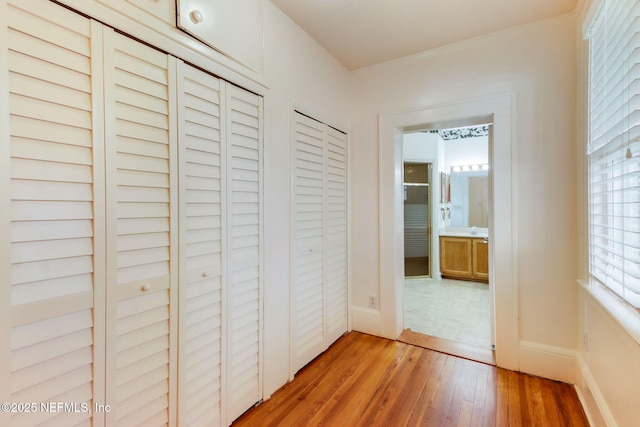 corridor with hardwood / wood-style flooring and crown molding