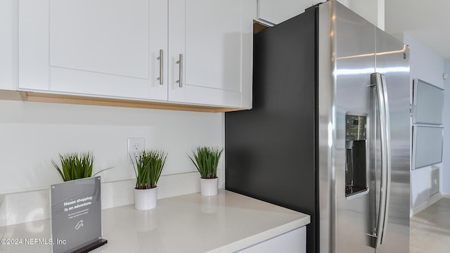 kitchen with white cabinets and stainless steel fridge