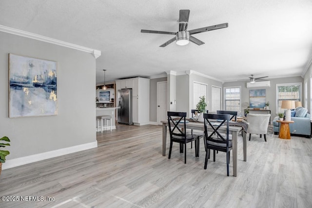 dining space featuring ceiling fan, light hardwood / wood-style flooring, crown molding, and a textured ceiling