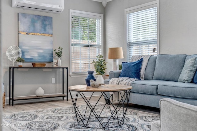 living room with light hardwood / wood-style floors and a wall mounted air conditioner