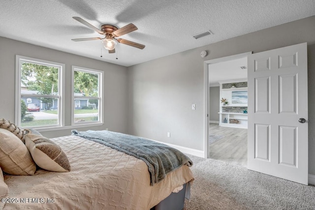 carpeted bedroom with a textured ceiling and ceiling fan