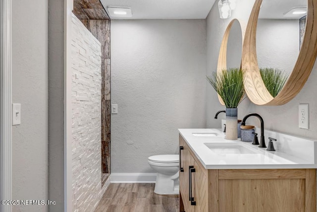 bathroom with toilet, vanity, and hardwood / wood-style floors