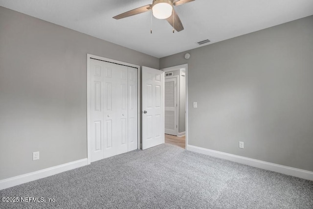 unfurnished bedroom with ceiling fan, a closet, and carpet flooring