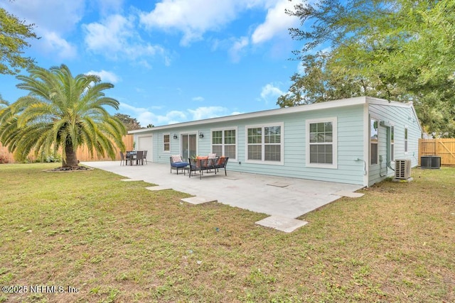 rear view of property with cooling unit, a patio, and a yard