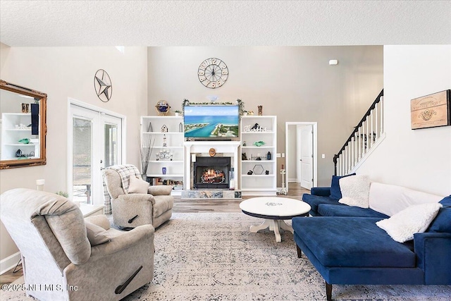 living room featuring french doors, wood-type flooring, and a textured ceiling