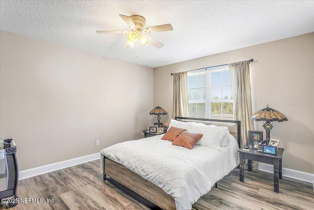 bedroom featuring ceiling fan, hardwood / wood-style floors, and a textured ceiling