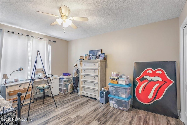 miscellaneous room with ceiling fan, hardwood / wood-style floors, and a textured ceiling