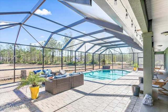 view of swimming pool featuring a patio, outdoor lounge area, and glass enclosure