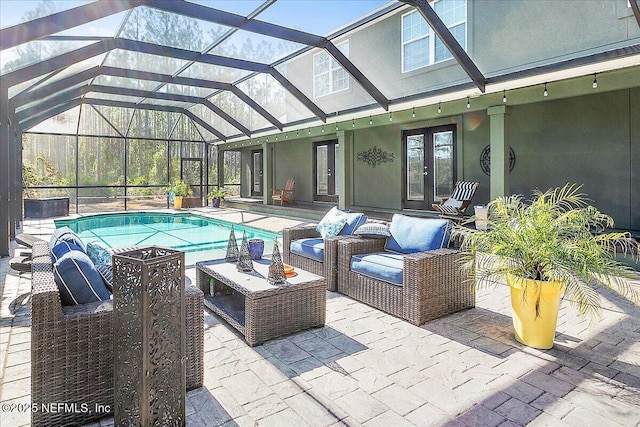 view of pool with french doors, outdoor lounge area, a patio area, and glass enclosure