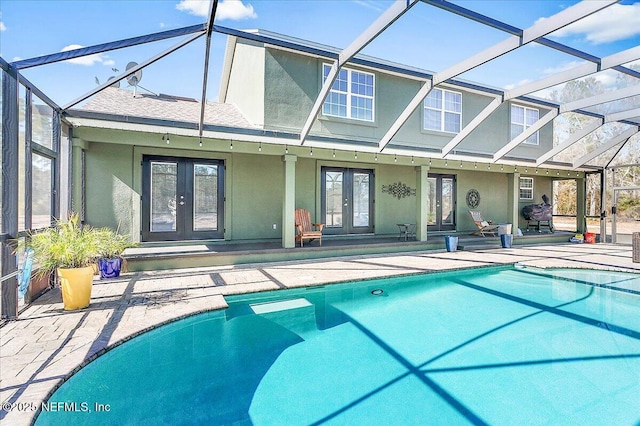 rear view of property with french doors, a patio area, and glass enclosure