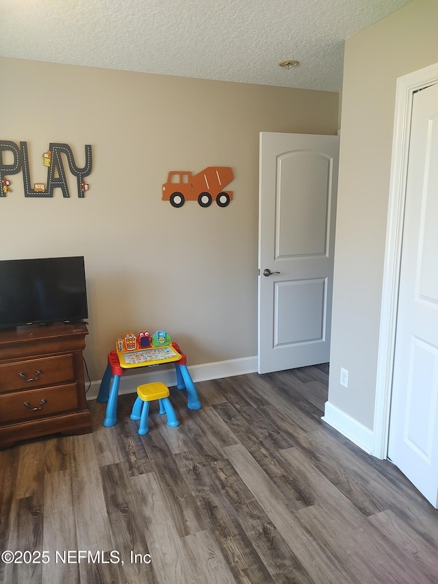 playroom with hardwood / wood-style flooring and a textured ceiling