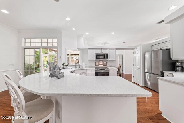 1814 Royal Fern Ln, Fleming Island, FL 32003 - kitchen featuring stainless steel appliances, a peninsula, recessed lighting, wood finished floors, and white cabinetry