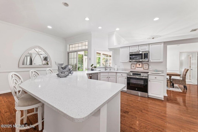 1814 Royal Fern Ln, Fleming Island, FL 32003 - kitchen with appliances with stainless steel finishes, a peninsula, a kitchen bar, crown molding, and a sink